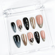 Black stiletto nails inspired set with smoky ombré, chrome, and floral accents.