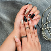 Black stiletto nails inspired set with smoky ombré, chrome, and floral accents.