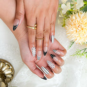 black and white striped nails medium almond press-on set with black French tips and polka dot accents