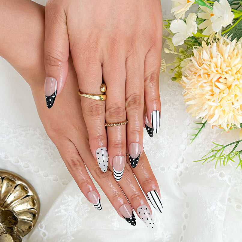 black and white striped nails medium almond press-on set with black French tips and polka dot accents