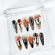 black silver nail art long stiletto press-on nails with black orange flower accents for fall winter holiday