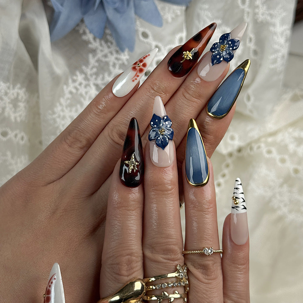 blue almond nails long stiletto press-on nails with blue gold and white accents flower detail winter holiday cool style
