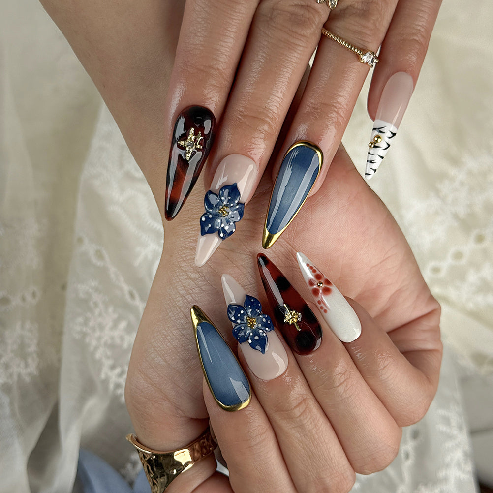 blue almond nails long stiletto press-on nails with blue gold and white accents flower detail winter holiday cool style