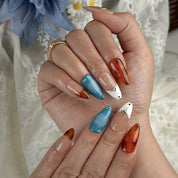 blue and orange nails medium almond press-on nails with nude base blue accents warm amber tips and simple nail art fall holiday style