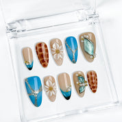 blue floral nails medium almond press-on nails with blue and brown accents flower details pearl-like accents luxury summer holiday style