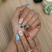 blue floral nails medium almond press-on nails with blue and brown accents flower details pearl-like accents luxury summer holiday style