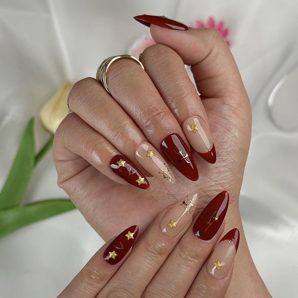 burgundy gold nail designs medium almond press-on nails with burgundy red nude accents french tips and gold star details for winter wedding style