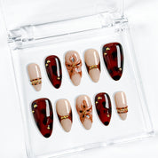 dark red nails design medium almond press-on nails with burgundy and brown tones gold accents and flower detail fall holiday style