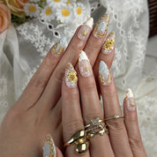 flower summer nails medium almond press-on nails in nude with gold details and yellow flower accents luxury summer beach party style