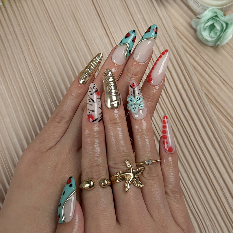 gold and nude nails long almond press-on nails with nude base green accents gold metallic luster and flower detail for summer holiday style