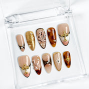 gold and nude nails medium almond press-on nails with nude base mocha brown accents gold shimmer and luxury details prom summer winter style