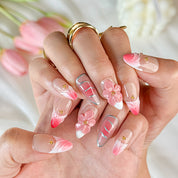 gold and nude nails medium almond pink press-on nails with flower accents and French tip detail