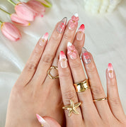 gold and nude nails medium almond pink press-on nails with flower accents and French tip detail