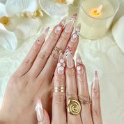 nail art white flowers long stiletto nude red press-on nails with French tip and floral detail