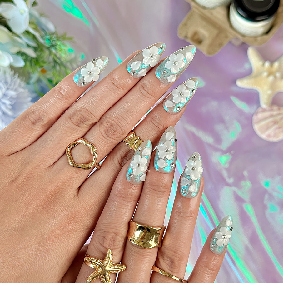 nail art white flowers medium almond blue white press-on nails with metallic luster and 3D floral design