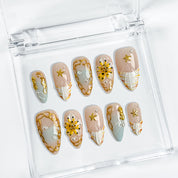 nail designs gold and white medium almond press-on nails with nude base gold details white accents yellow flower and pearl touches summer beach party style