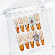 nail designs zebra long square nude orange press-on nails with flower accents and zebra French tip detail