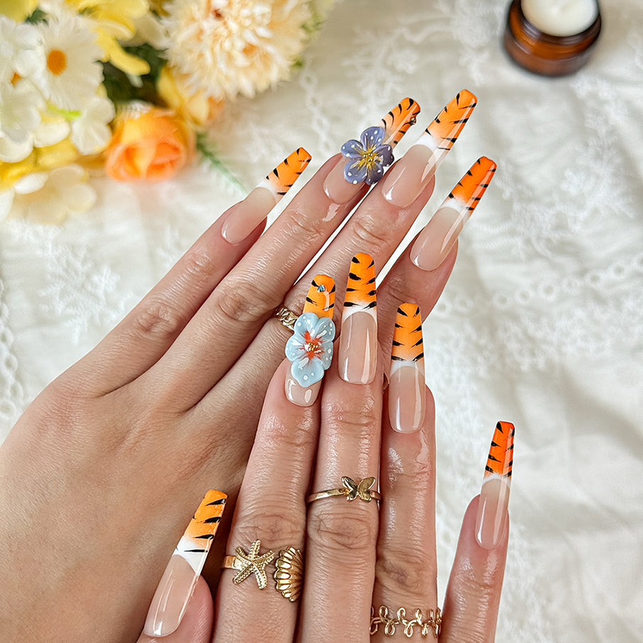 nail designs zebra long square nude orange press-on nails with flower accents and zebra French tip detail