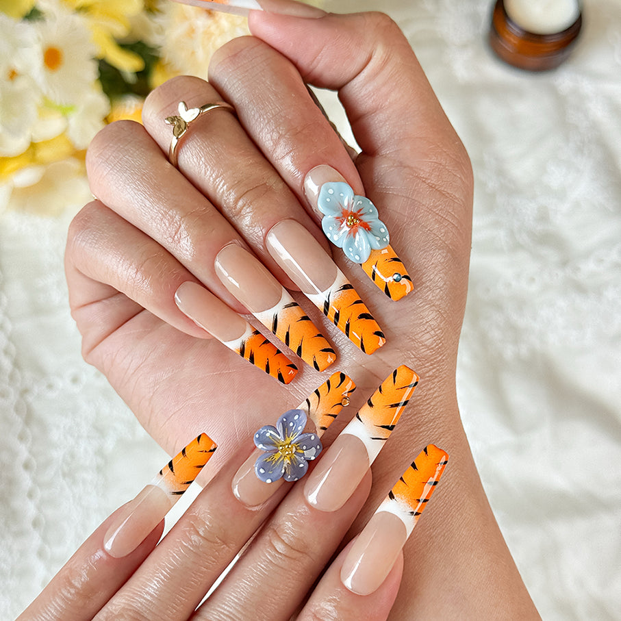 nail designs zebra long square nude orange press-on nails with flower accents and zebra French tip detail