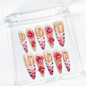 nail designs zebra long stiletto nude pink press-on nails with flower accents and zebra French tip detail