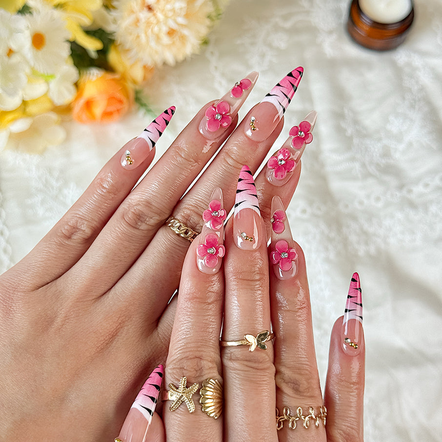 nail designs zebra long stiletto nude pink press-on nails with flower accents and zebra French tip detail