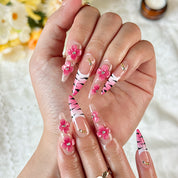nail designs zebra long stiletto nude pink press-on nails with flower accents and zebra French tip detail