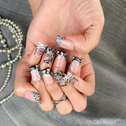 nail designs zebra short square black press-on nails with nude base, zebra print tips, and cute winter holiday accents