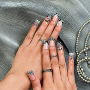 nail designs zebra short square black press-on nails with nude base, zebra print tips, and cute winter holiday accents