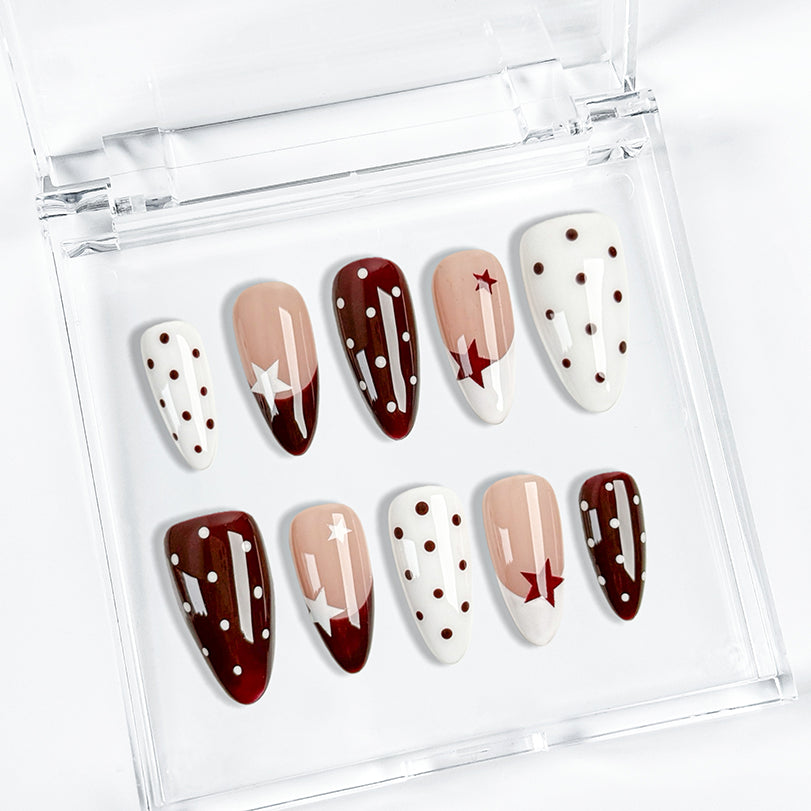 nails white and pink medium almond press-on nails with white and cocoa-red french tips, polka dots, and star accents for fall holiday look