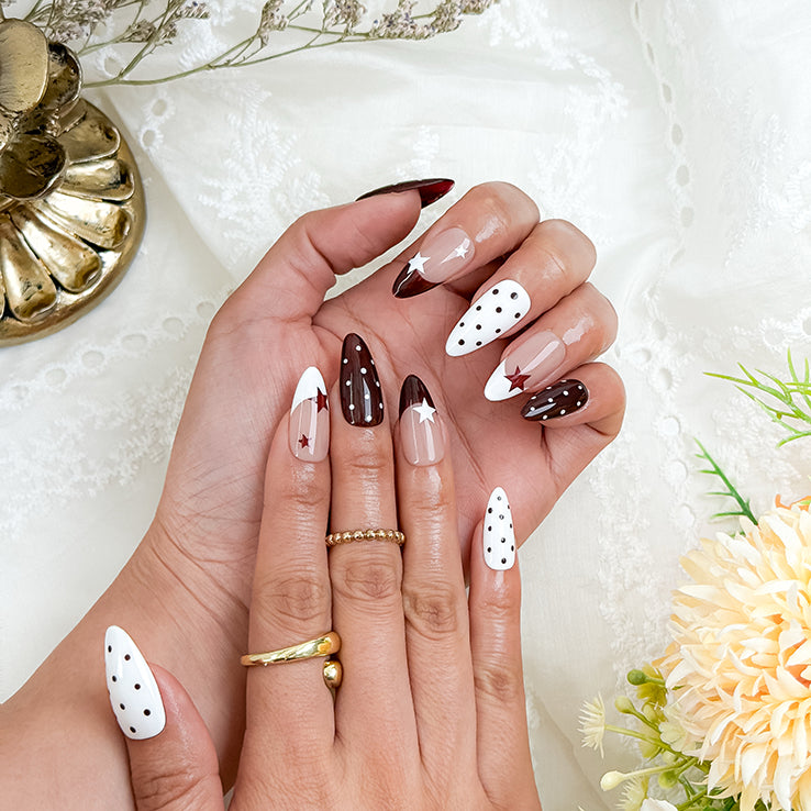 nails white and pink medium almond press-on nails with white and cocoa-red french tips, polka dots, and star accents for fall holiday look