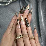 nude brown nails long stiletto press-on nails with brown and black french tips subtle gold accents fall holiday cool style