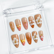 nude nails with flowers medium almond press-on nails in brown nude with 3D white flower accents and gold details for spring wedding beach party style