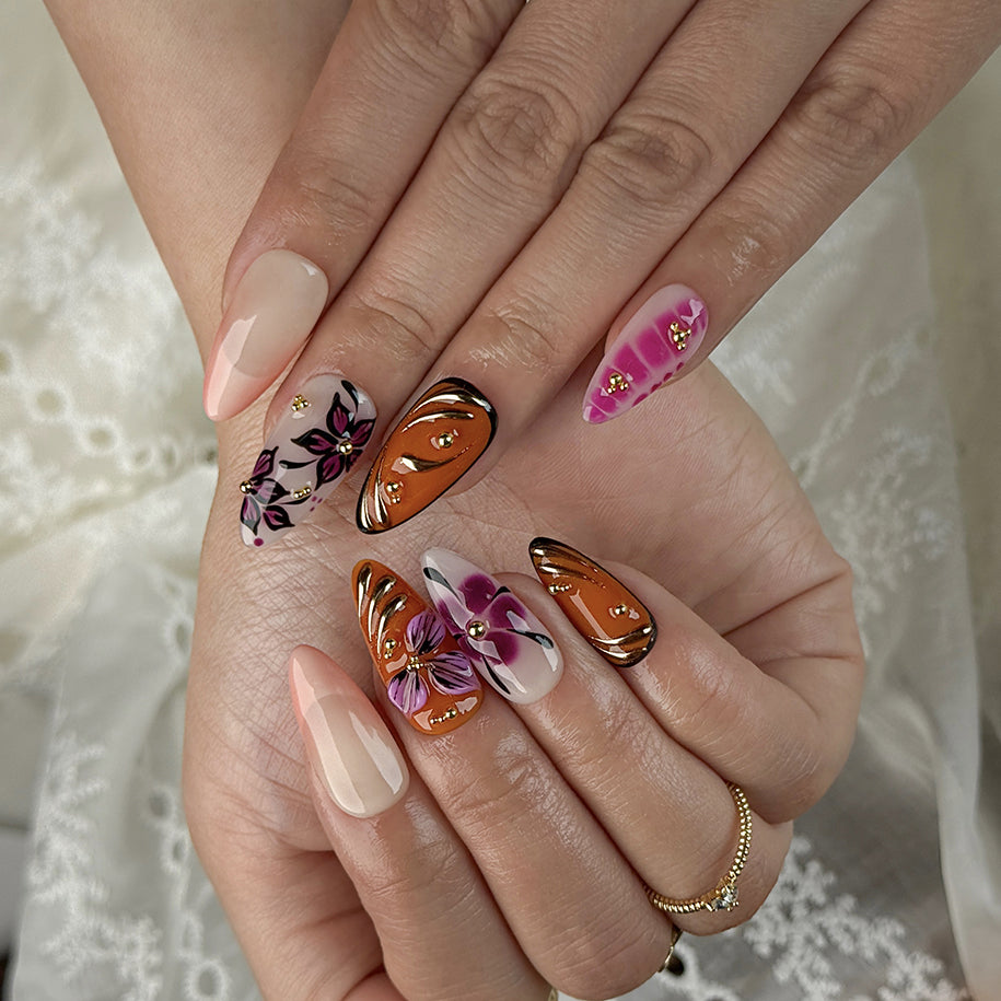 orange nails with designs medium almond press-on nails with pink floral accents and gold metallic highlights for summer and prom