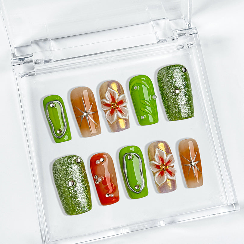 pastel green nails medium square press-on nails with green and orange accents metallic luster and flower details spring beach party style