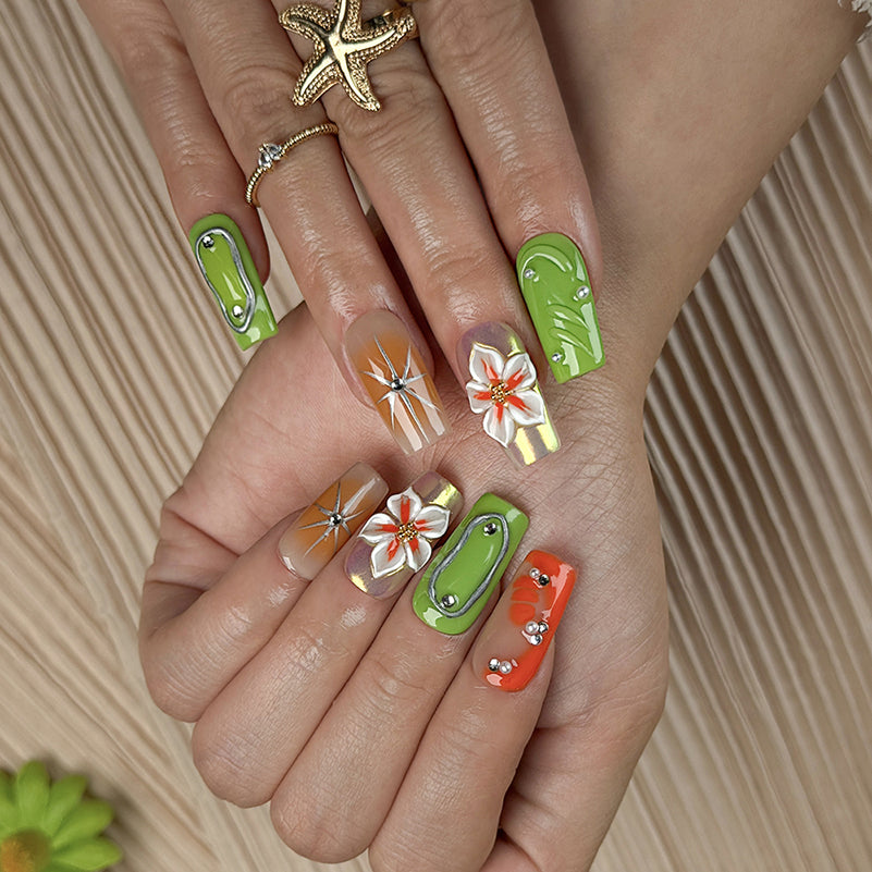 pastel green nails medium square press-on nails with green and orange accents metallic luster and flower details spring beach party style