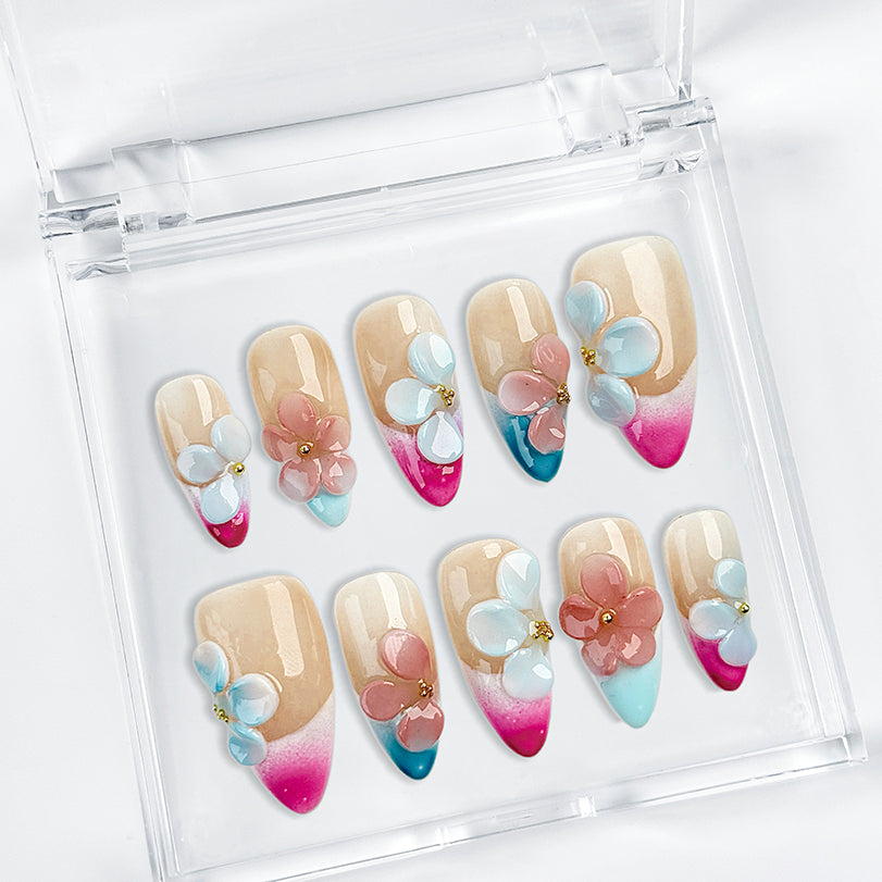 pink and nude nails medium almond press-on nails with blue French tip accents and 3D flower details