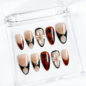 red black nail art medium almond press-on nails with nude base black accents brown marble details and flower accent fall winter holiday style