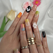 sunset pink and orange ombre nails short square press-on nails with black accents colorful ombre tips and flower details spring beach party style